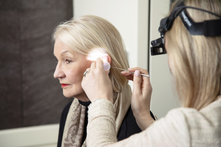 Audiologist performing an ear wax removal procedure on a patient at AudioLogic Hearing.