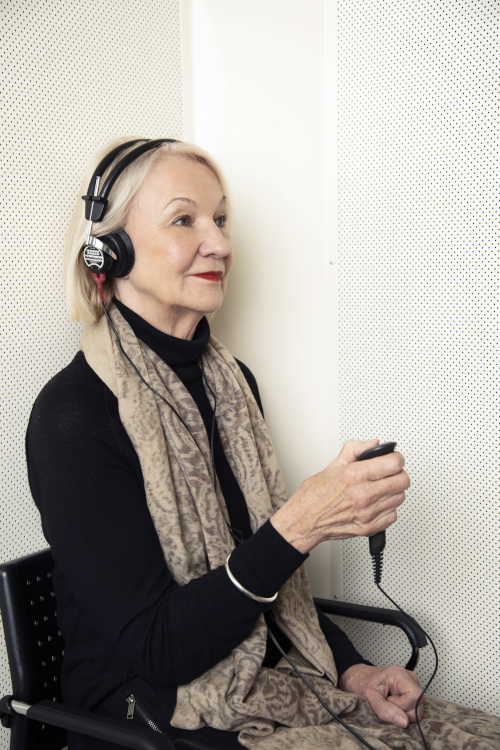 Seated woman undergoing a hearing test at AudioLogic Hearing.